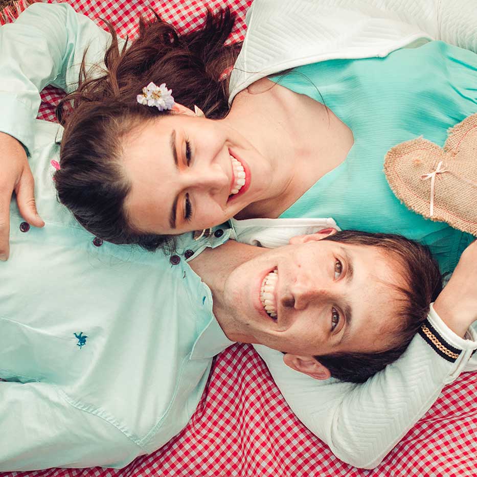 Fotografia tomada en picada de pareja de novios acostados boca arriba